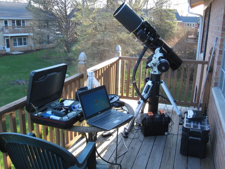 A refractor on a deck with Raspberry Pis running StellarMate, controlled from a laptop with KStars